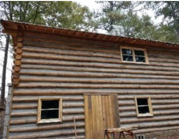 A log cabin with a wooden door and windows