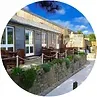 Cafe with outdoor seating under a bright blue sky.