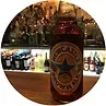 Newcastle Brown Ale bottle on a bar, bottles in background.