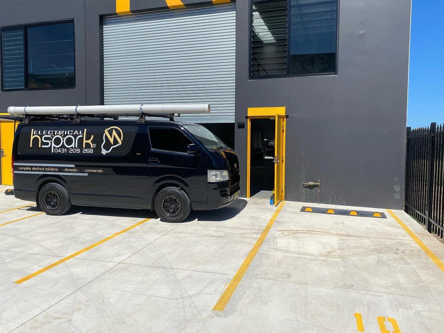 Black Van Parked Outside a Commercial Building — Hspark Electrical PTY LTD in Appin, NSW