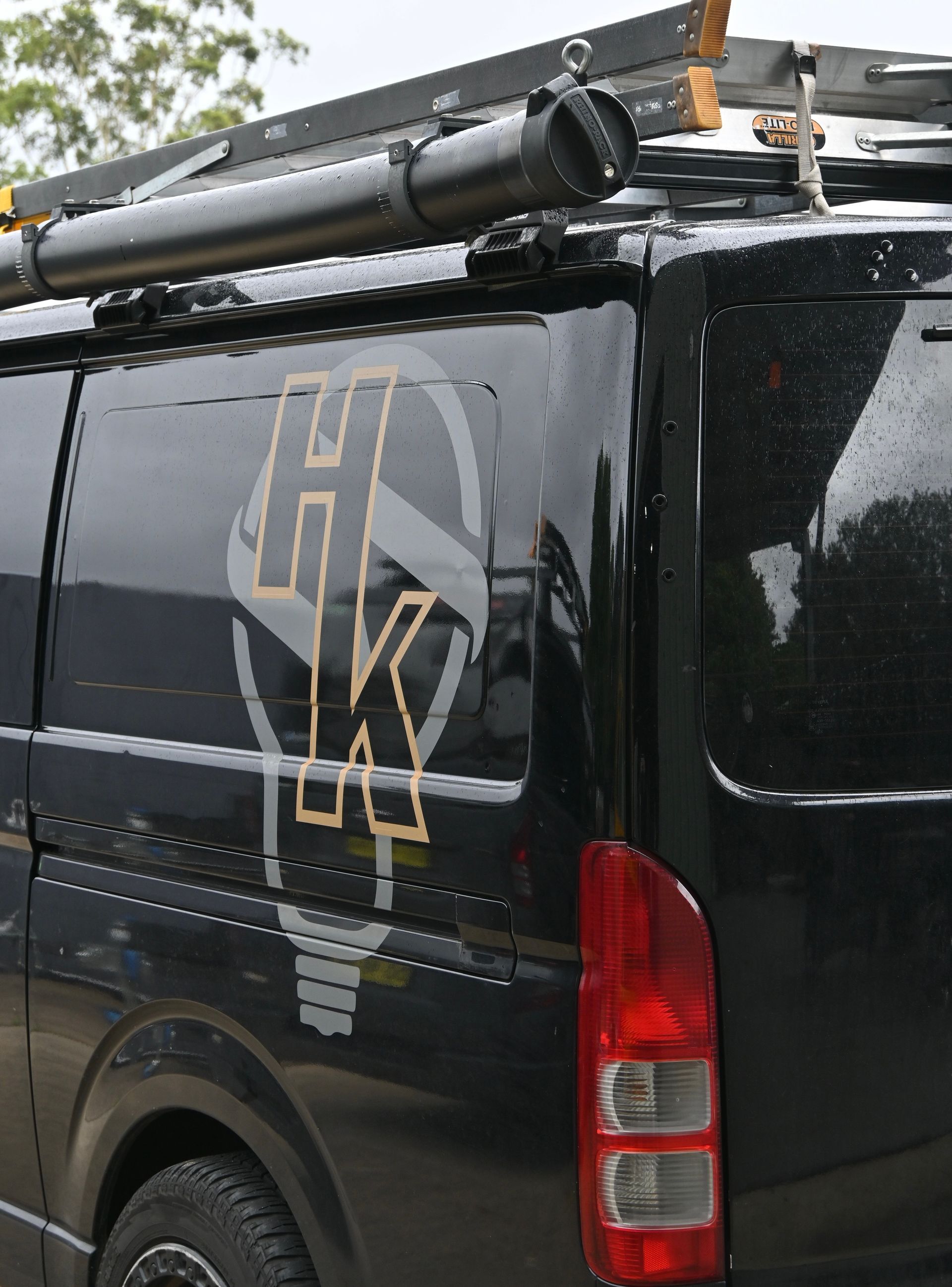 Black van with a lightbulb graphic containing the letters 