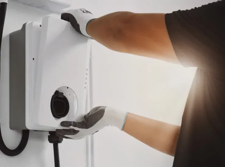 A Man Installing an EV Charger in a Garage — Hspark Electrical PTY LTD in Appin, NSW