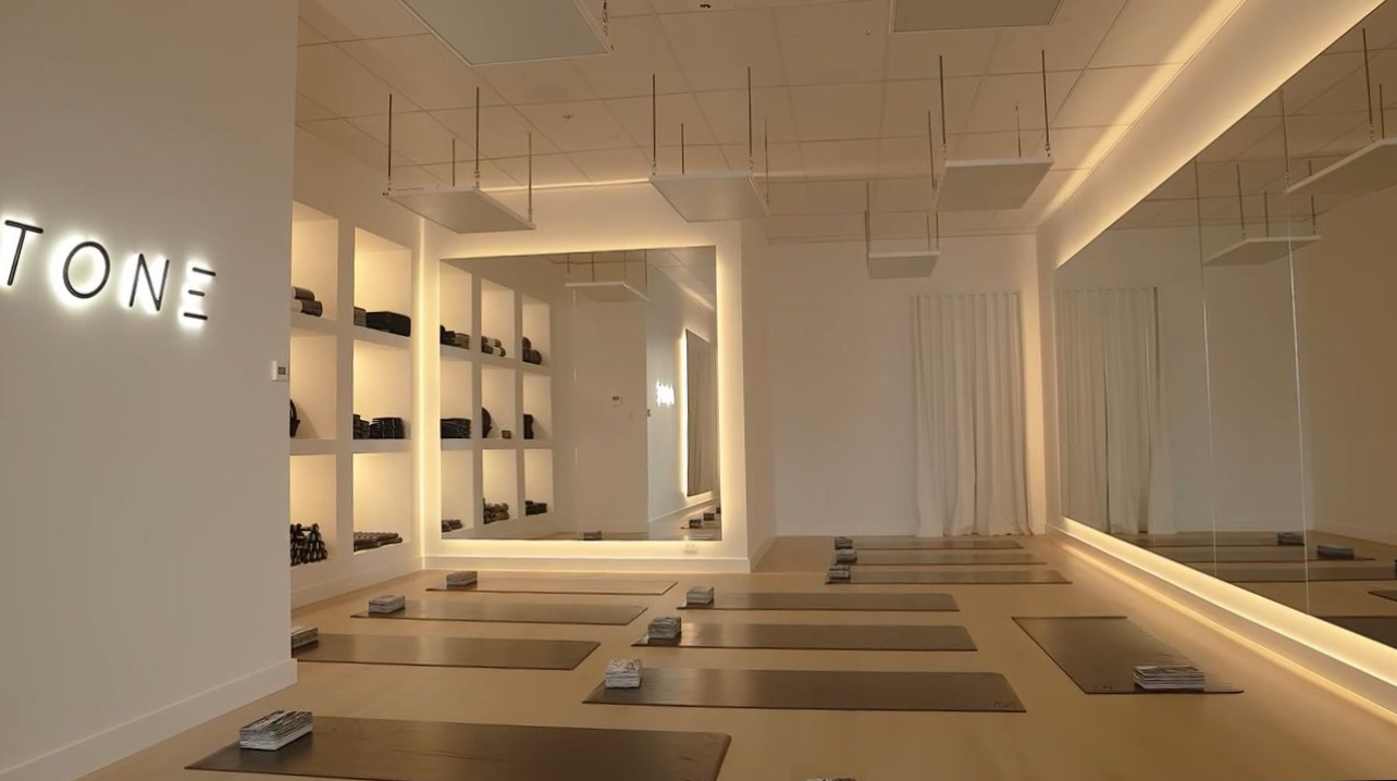A minimalist yoga or fitness studio with yoga mats on the floor, lit shelving, and a large wall mirror — Hspark Electrical PTY LTD in Appin, NSW