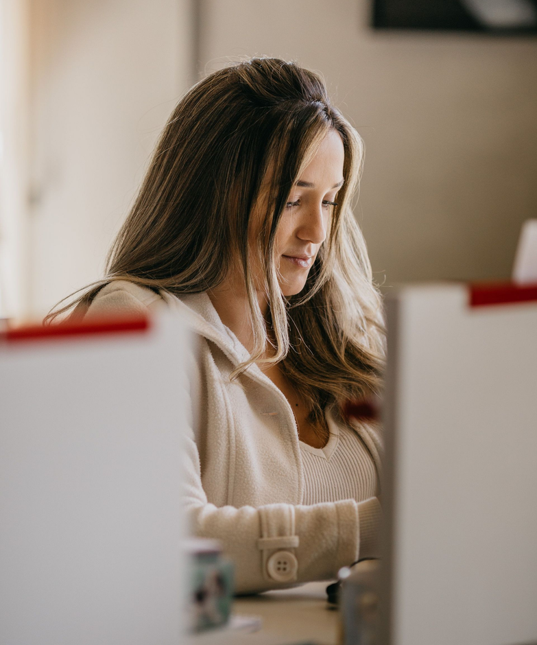 Small business owner working at a laptop in a warm, professional workspace