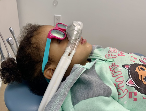 A young child laying in a dental chair with an oxygen mask on his face, sedation dentistry near Tarrytown NY