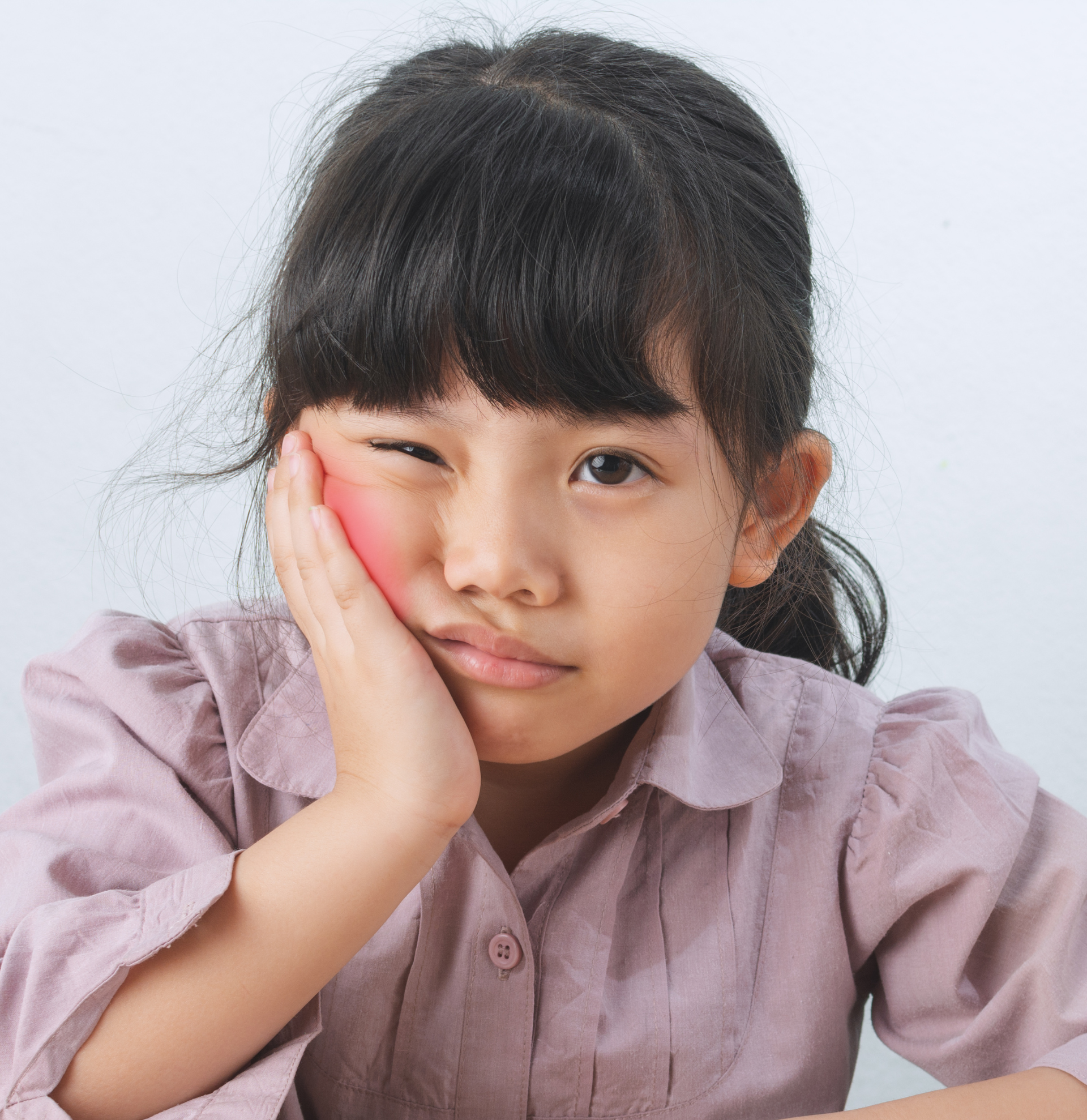 A little girl with her hand on her face making a sad face | Pediatric Dentist near Tarrytown NY