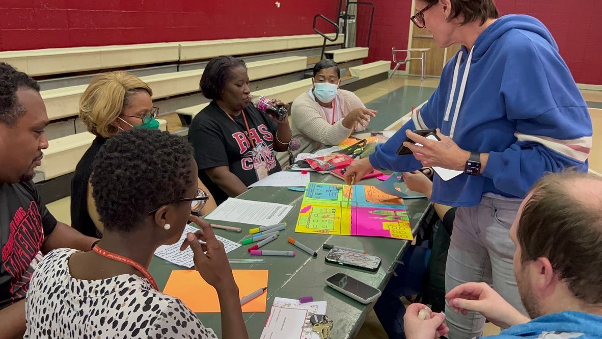 A group of people are sitting around a table making crafts.