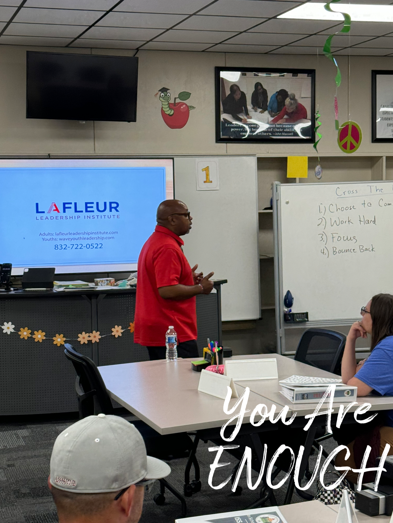 A man in a red shirt is giving a presentation to a group of people.