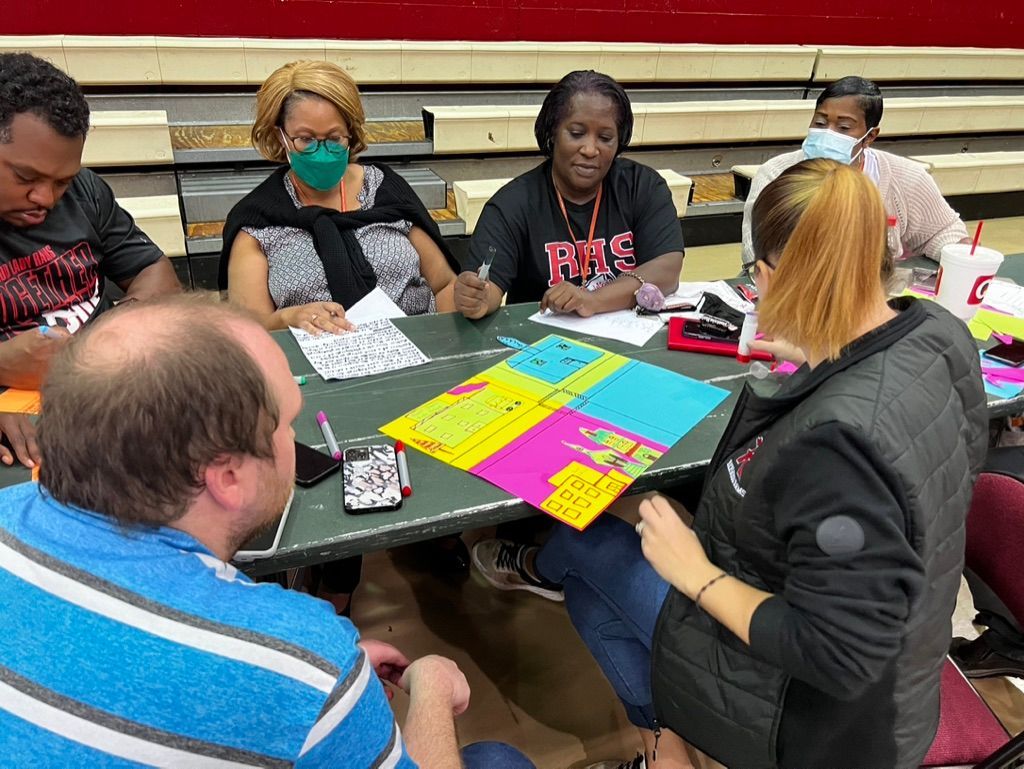 A group of people are sitting around a table with papers on it.
