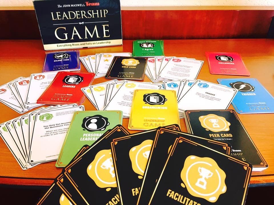 A bunch of cards on a table with a sign that says leadership game