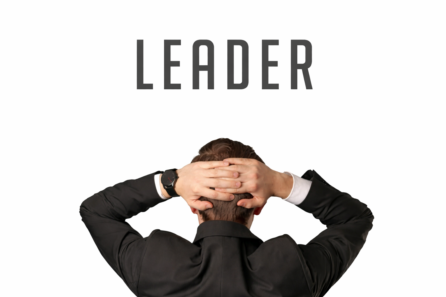 Person in suit, hands behind head, looking upwards at the word