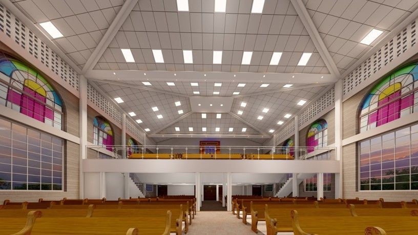 Bright church interior with rows of wooden pews, high arched ceiling, and colorful stained-glass windows.