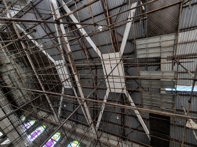 Curved metal roof trusses and corrugated panels inside an industrial building