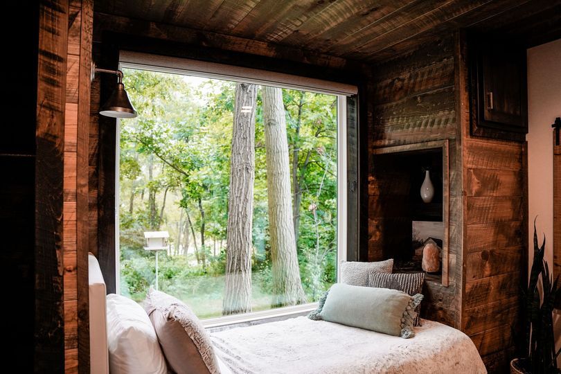 There is a large window in the dining room with a view of a lake.