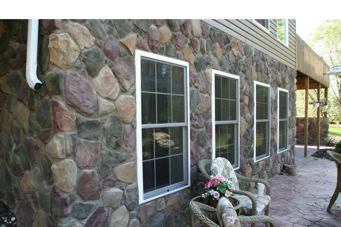 A stone wall with a row of windows on it