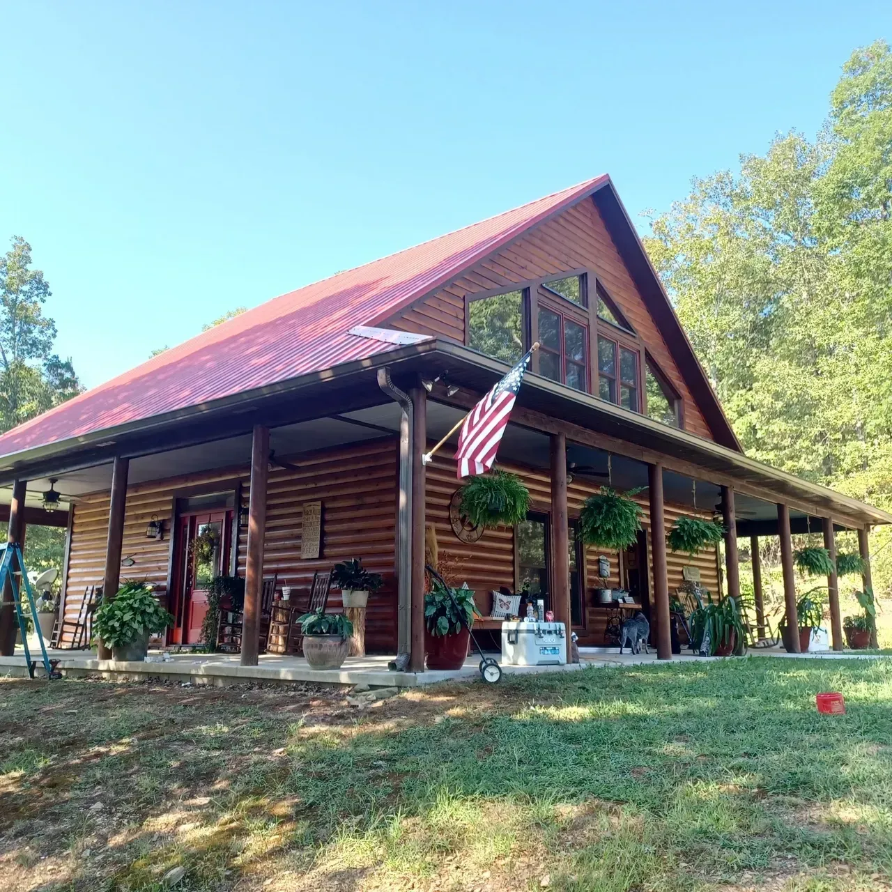 A large wooden house with a red roof and a porch