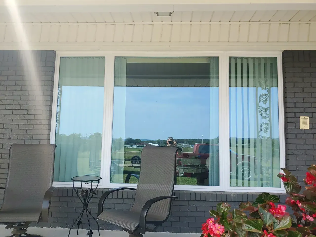 A porch with chairs a table and a large window replacement in Damascus, AR
