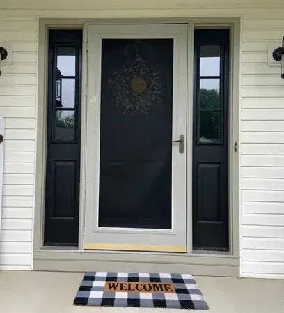 There is a welcome mat in front of the door.