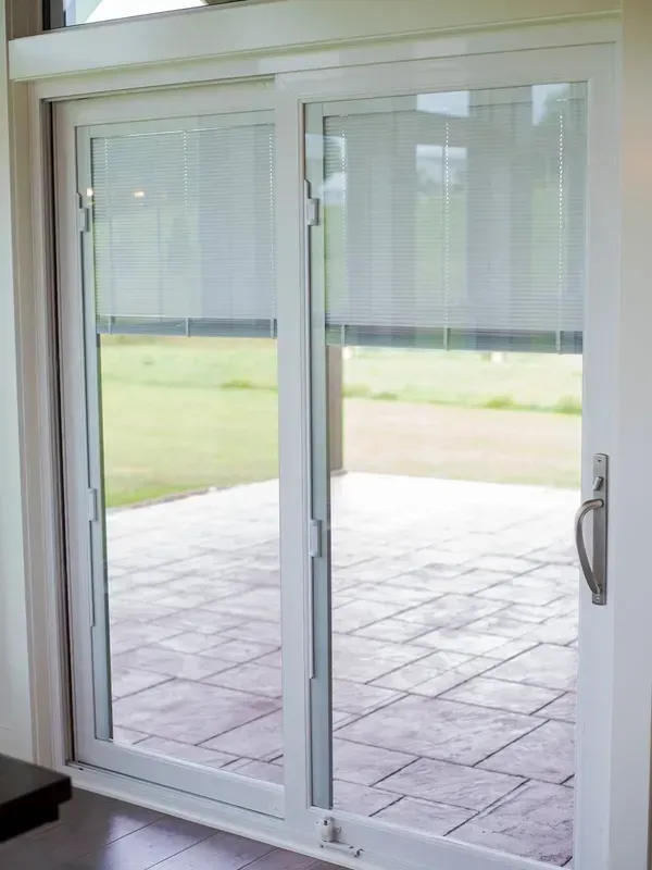 A white sliding glass door is open to a patio.