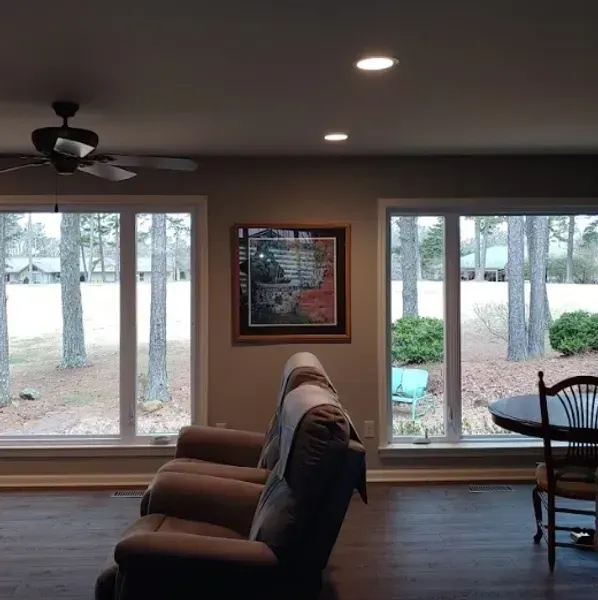 A living room with a couch and chairs and a ceiling fan