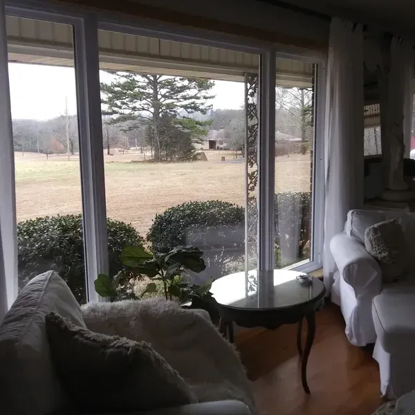 A living room with a view of a field through a sliding glass door