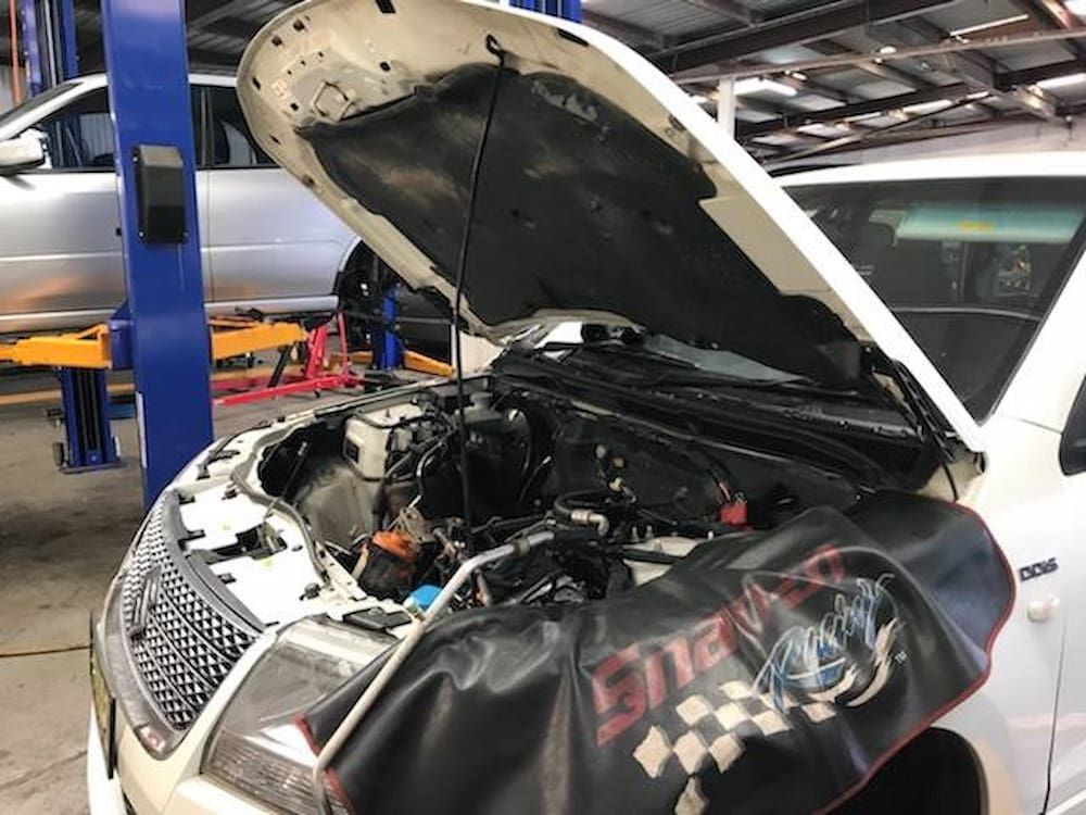A White Car With The Hood Open In A Garage — Sojos Mechanical & Tyre Service In West Gosford, NSW