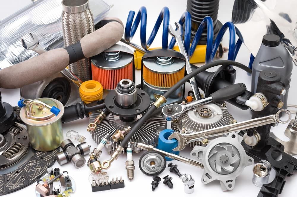 A Bunch Of Car Parts On A White Surface — Sojos Mechanical & Tyre Service In Kariong, NSW