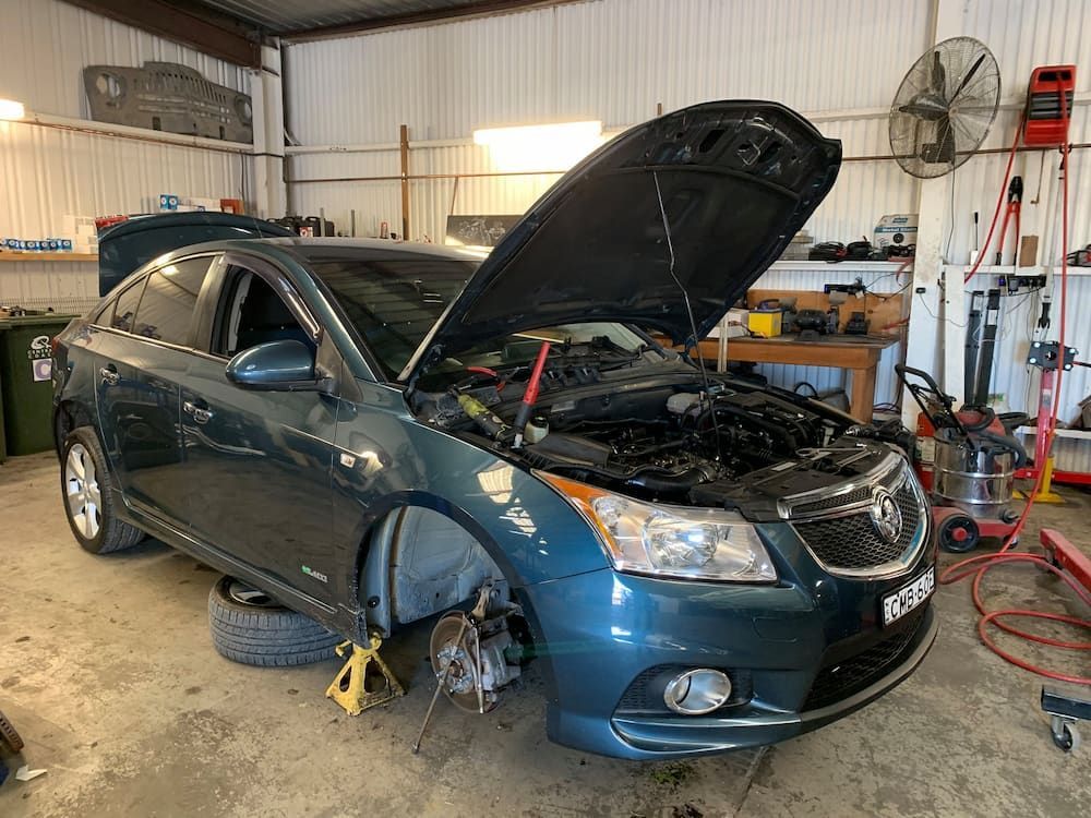 A Blue Car With The Hood Open Is Sitting In A Garage — Sojos Mechanical & Tyre Service In West Gosford, NSW