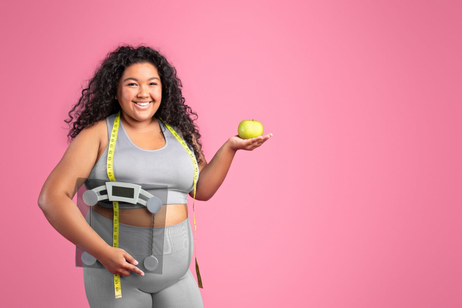A Woman Is Measuring Her Waist and Holding an Apple — Great Bends, KS — Innovative Wellness