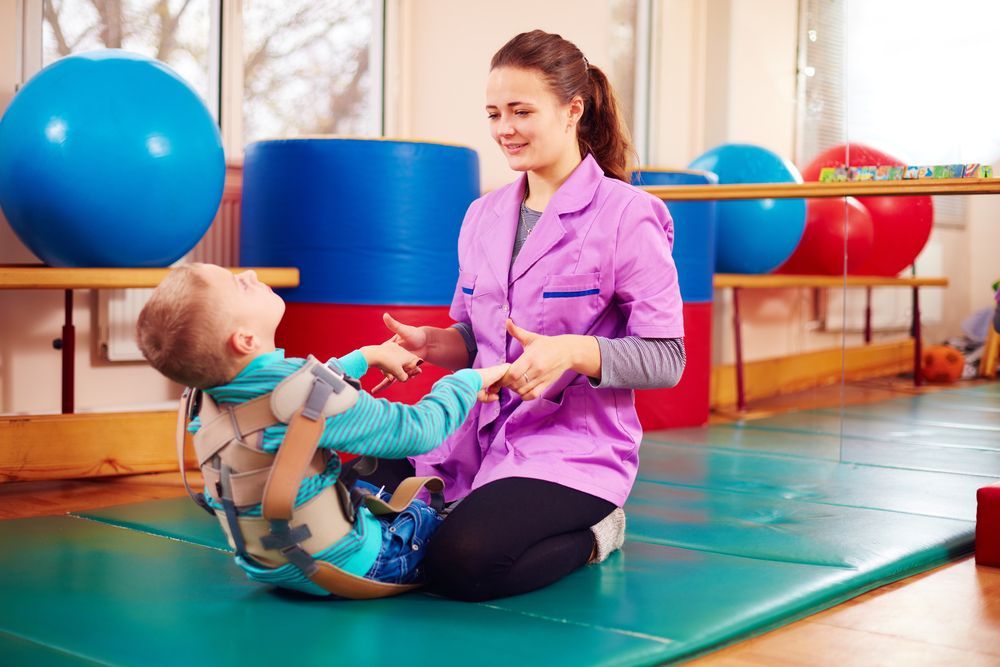 Woman Helping a Child Stretch on a Gym Mat — Accredited Training in Rockhampton QLD