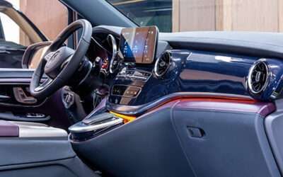 Luxury car interior with blue dashboard, leather seats, and a steering wheel with center display