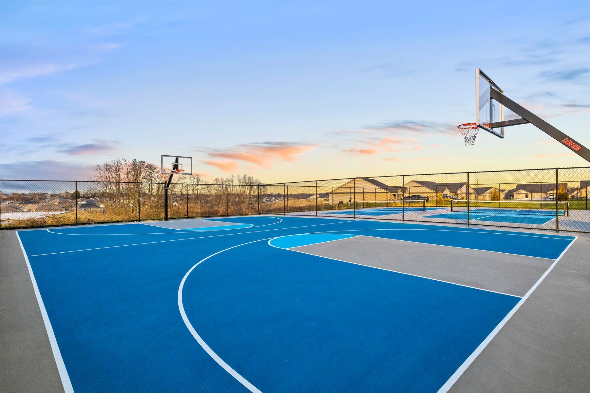 A boy in a blue shirt is throwing a basketball into a basketball hoop.