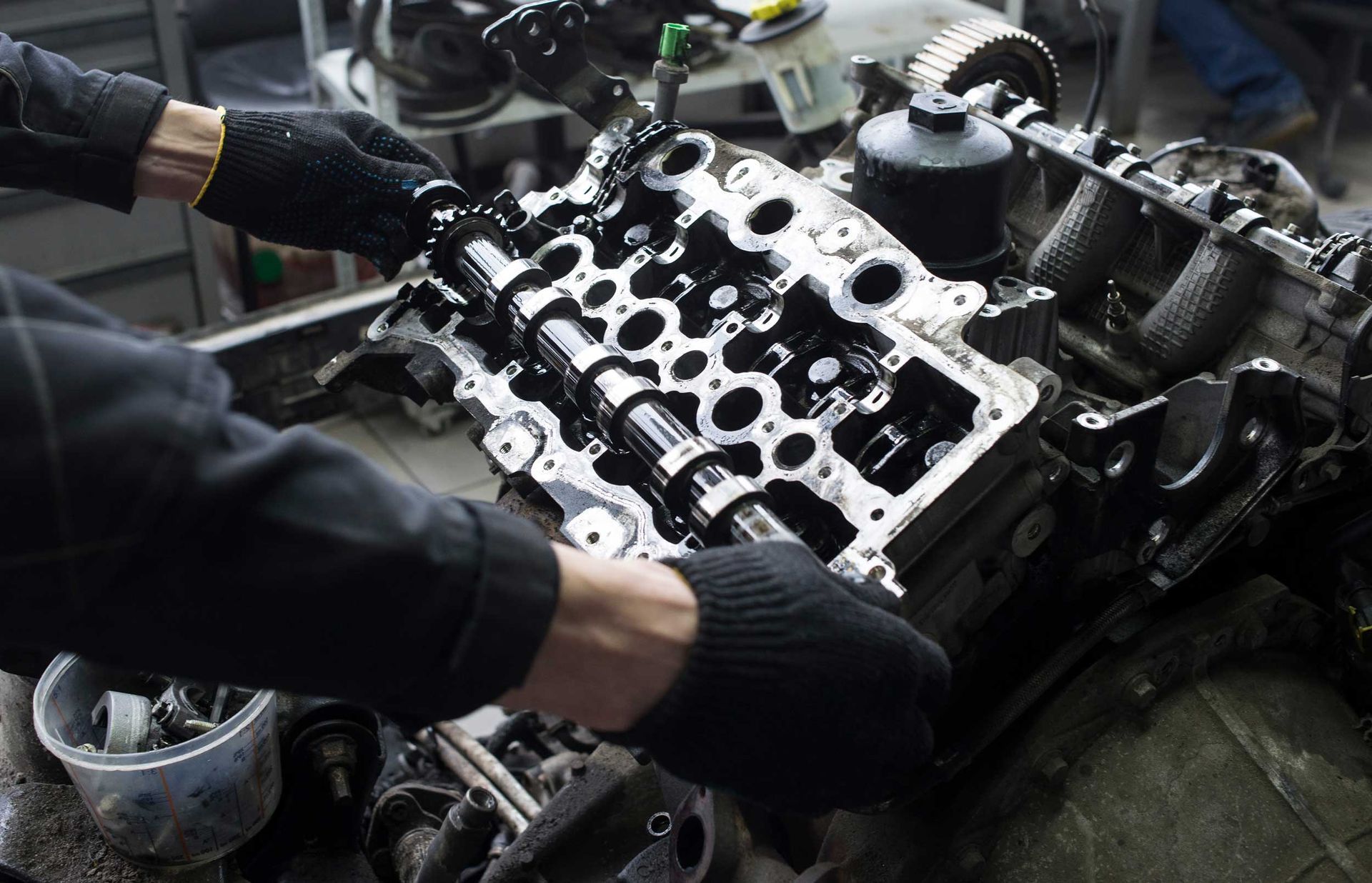 An unrecognized mechanic is working on a V8 car engine.