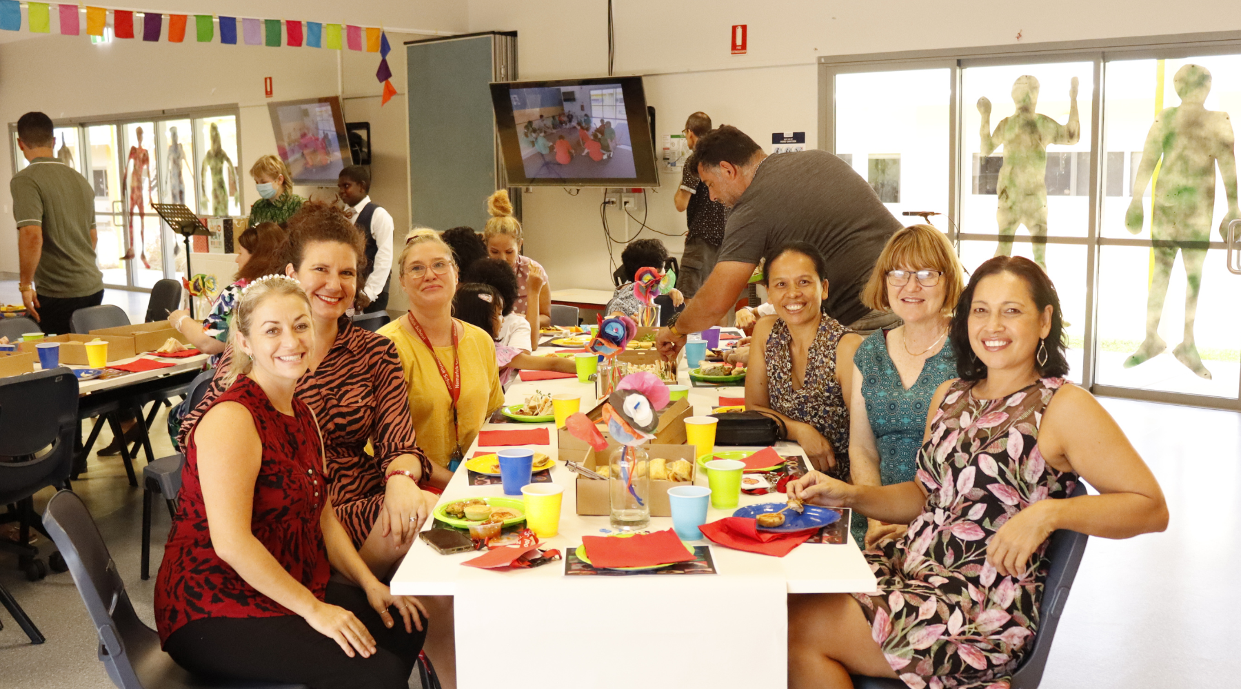 A group of people are sitting at a table with plates of food.