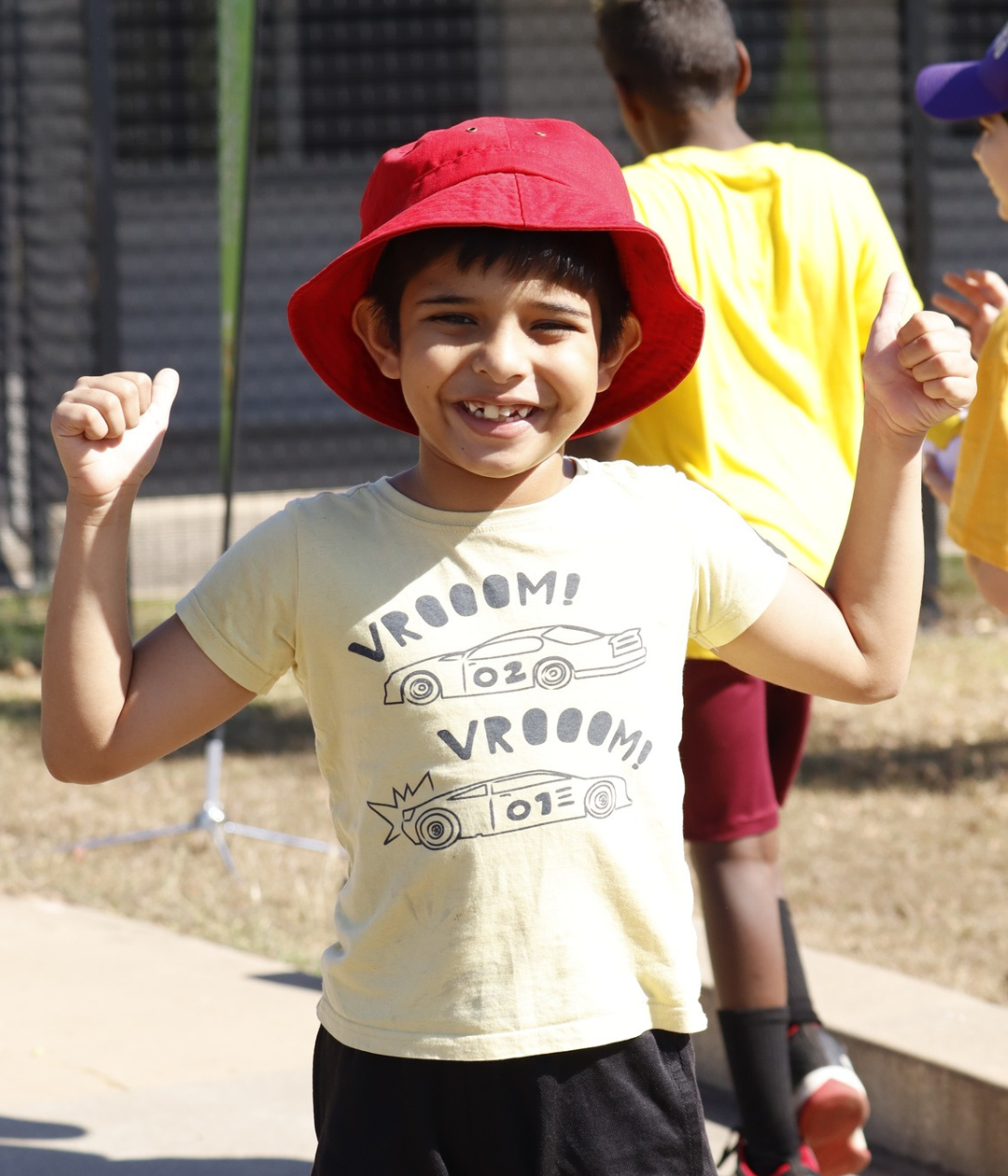 A young boy wearing a yellow shirt that says vroom