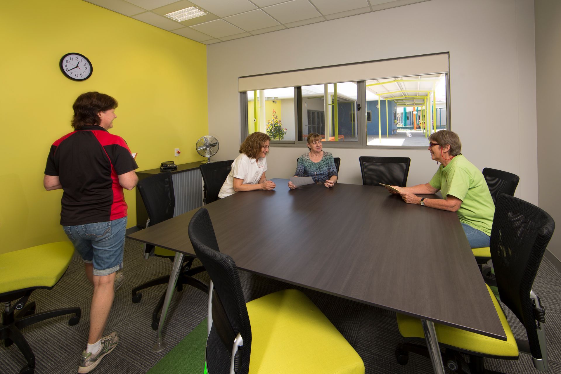 A group of people are sitting around a table in a conference room.