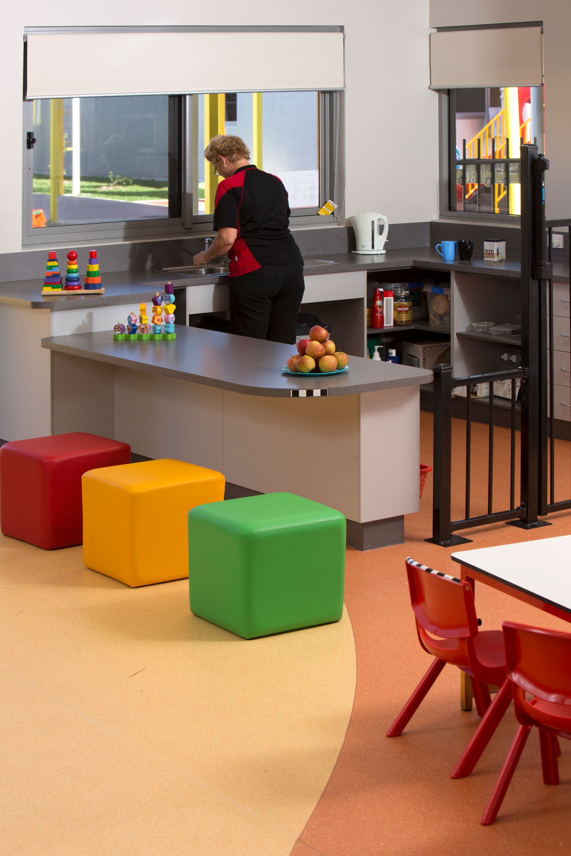 A woman is standing at a counter in a kitchen