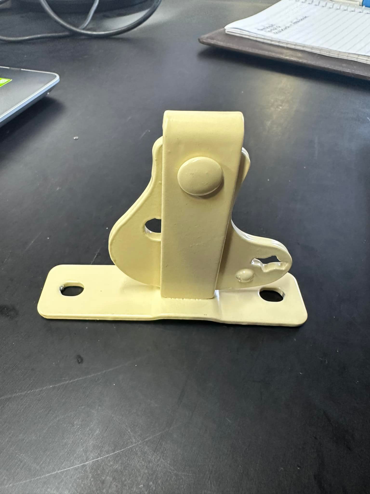 Beige Metal Latch With a Hinged Lever and Mounting Plate, Set on a Dark Surface — Metal Fencing Supplies In Forster, NSW