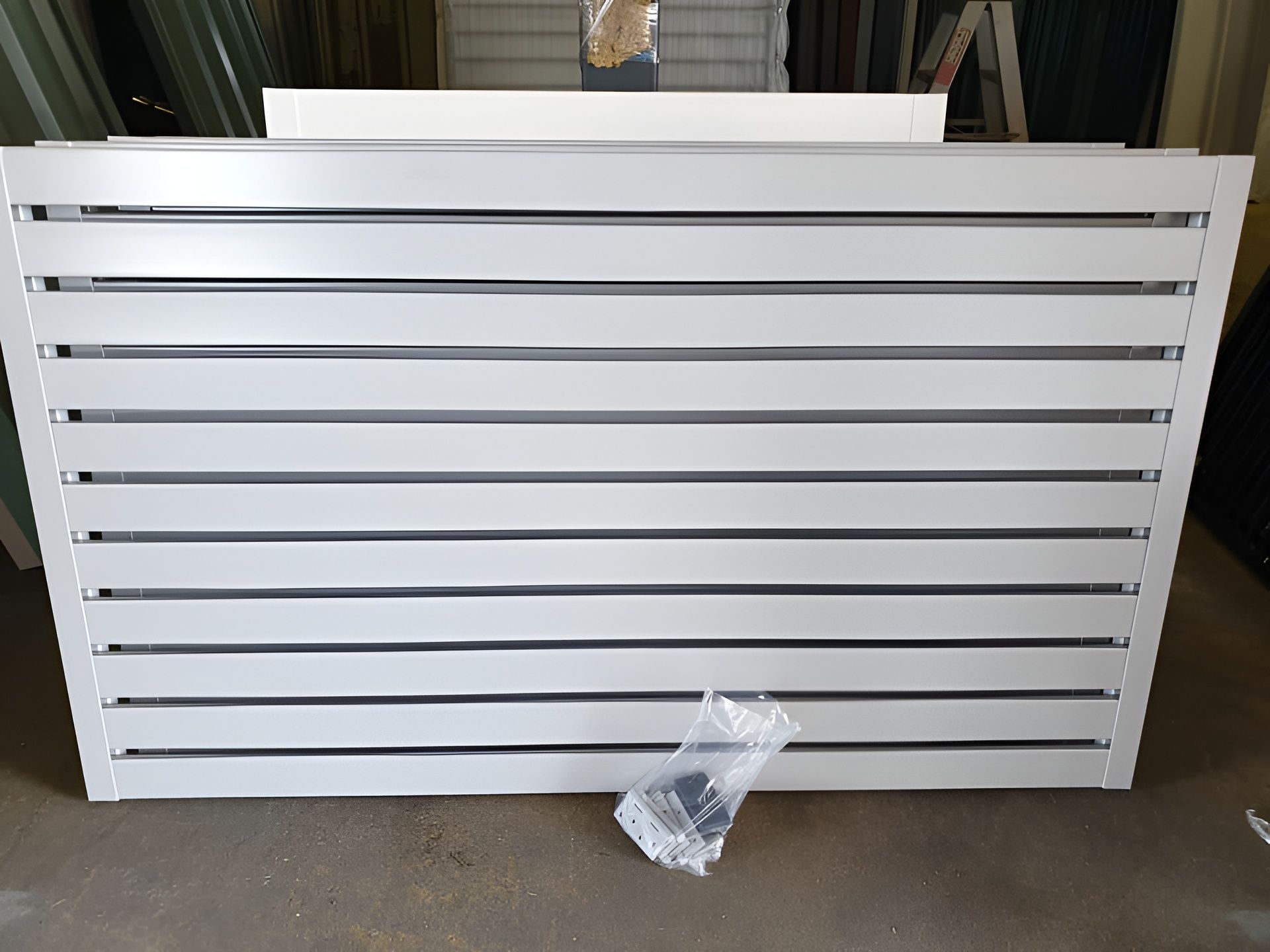 White Horizontal Slat Fence With Mounting Hardware in Front — Metal Fencing Supplies In Forster, NSW
