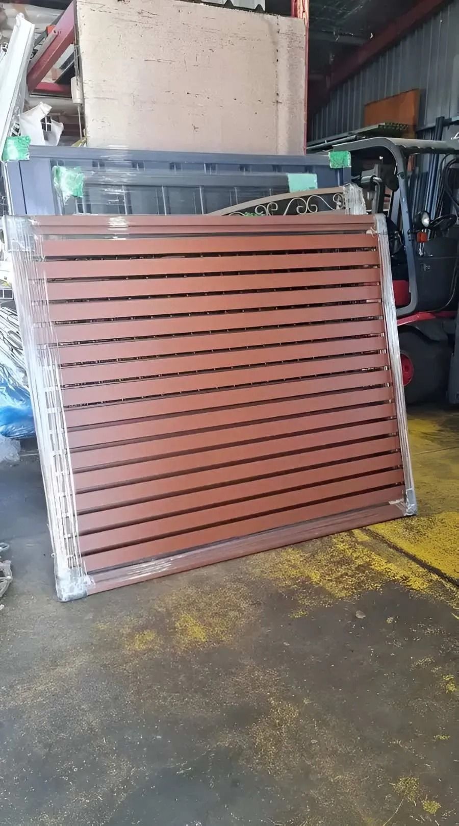 Stack of Brown Horizontal Slat Fence Panels — Metal Fencing Supplies In Taree, NSW
