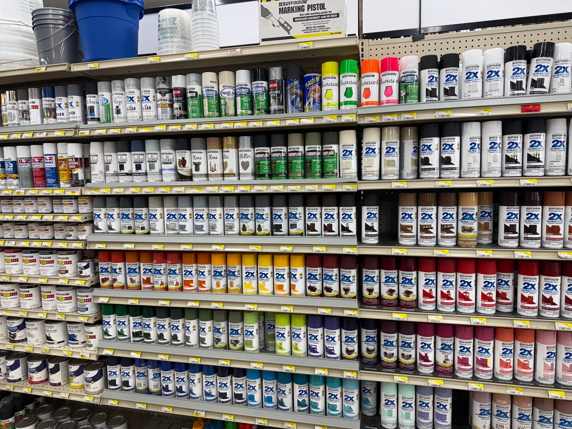 A store shelf packed with rows of colorful spray paint and paint cans.