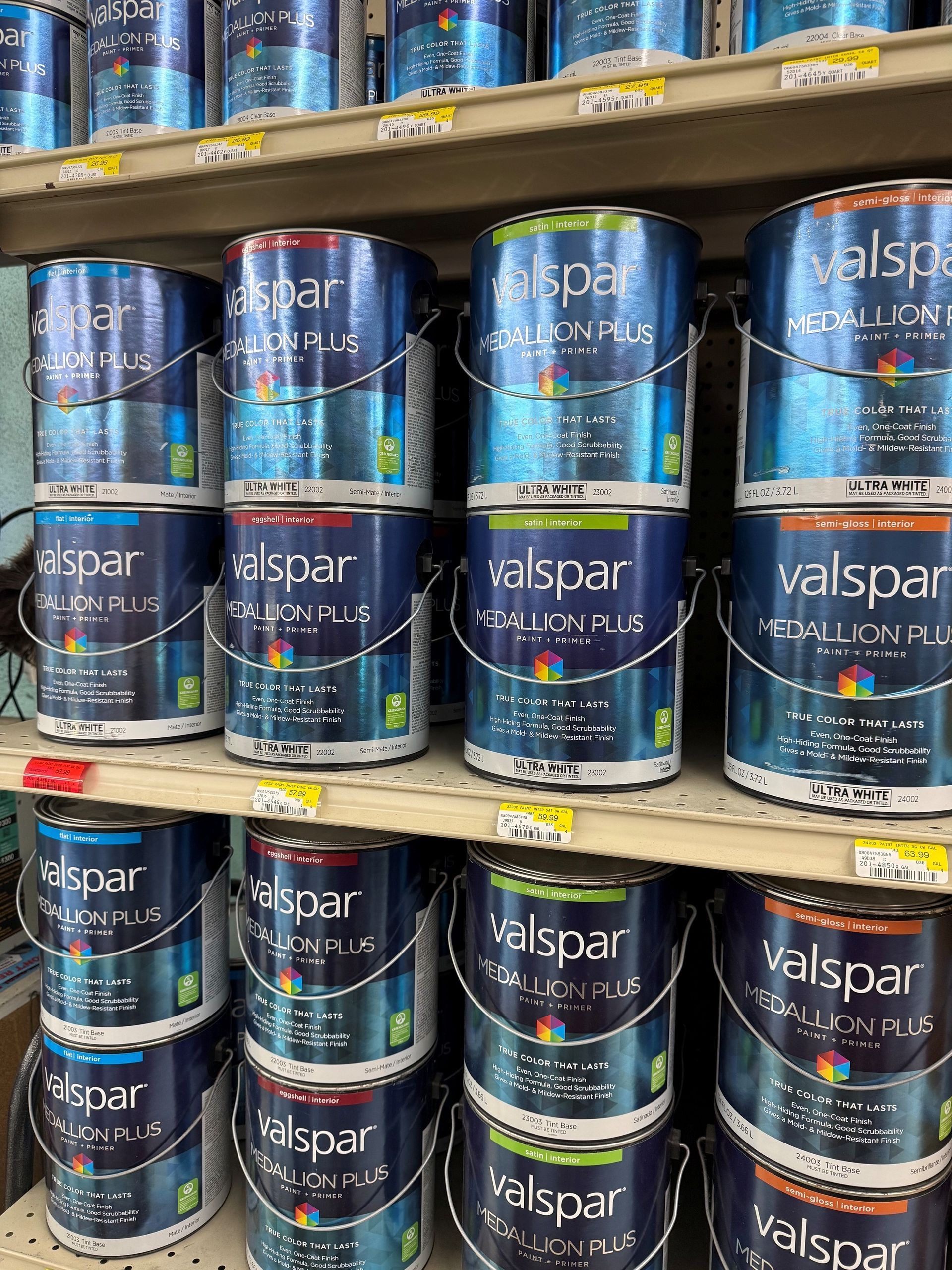 Shelves of stacked Valspar paint cans in a hardware store aisle