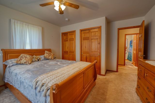 Spacious modern bedroom with a king size bed and ceiling fan.