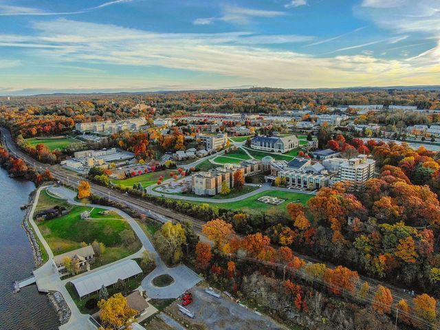 Aerial city photography captures a stunning view of a city surrounded by trees and a river.