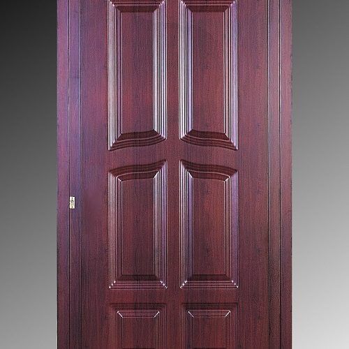 Porta chiusa con pannelli in legno scuro e sezioni in rilievo decorate.