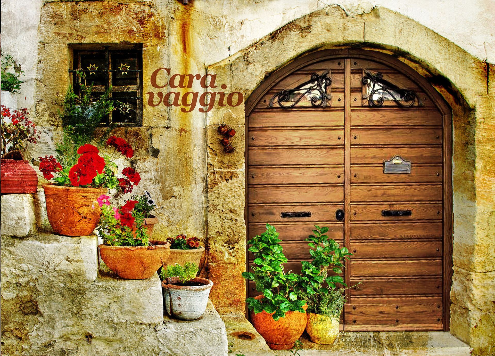 Portale rustico in pietra con porta ad arco in legno e colorati vasi di fiori sui gradini e sul muro.