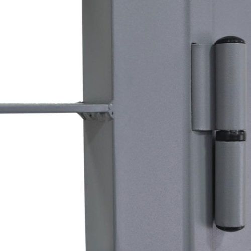 Primo piano di una cerniera per porta in metallo grigio su una superficie grigio chiaro.