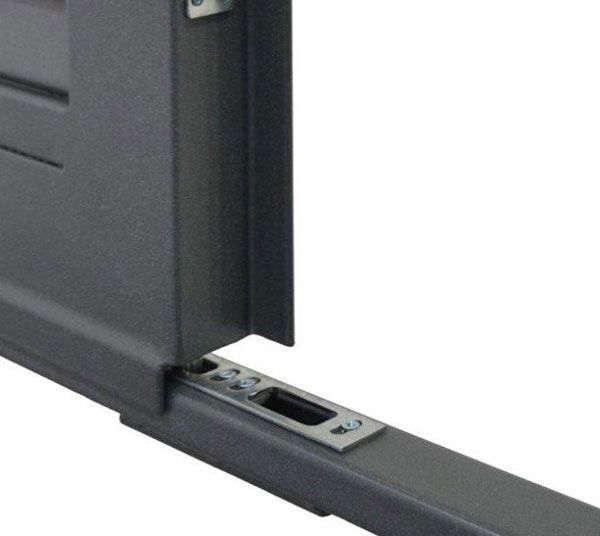 Primo piano di un cassetto o pannello in metallo grigio che scorre in una guida con un meccanismo di chiusura.