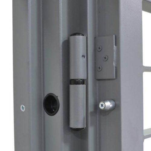 Primo piano di una cerniera e di un chiavistello argentati su un telaio di porta in metallo grigio.