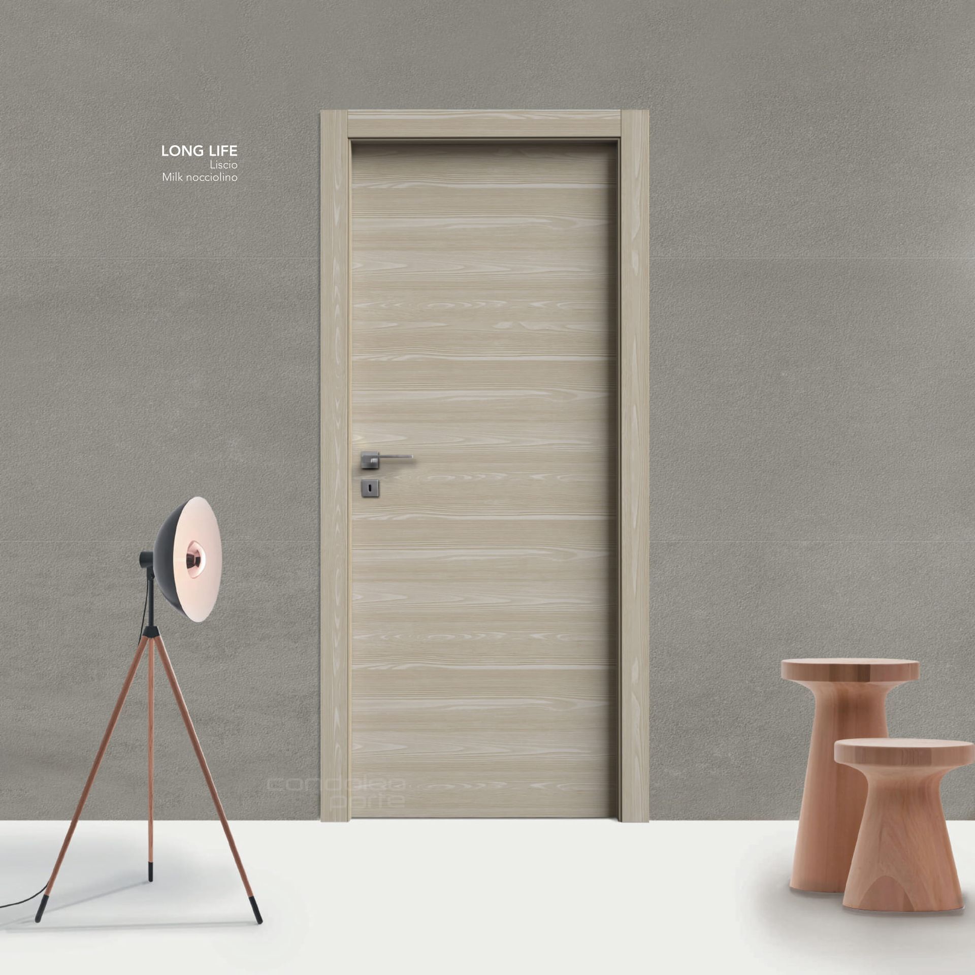 Stanza minimalista con porta beige, lampada a treppiede e piccoli sgabelli in legno contro una parete grigia.